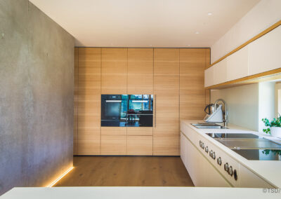 Küche in Weißtanne und weißen Fronten mit Bora Geräten, modern und mit Sichtbeton