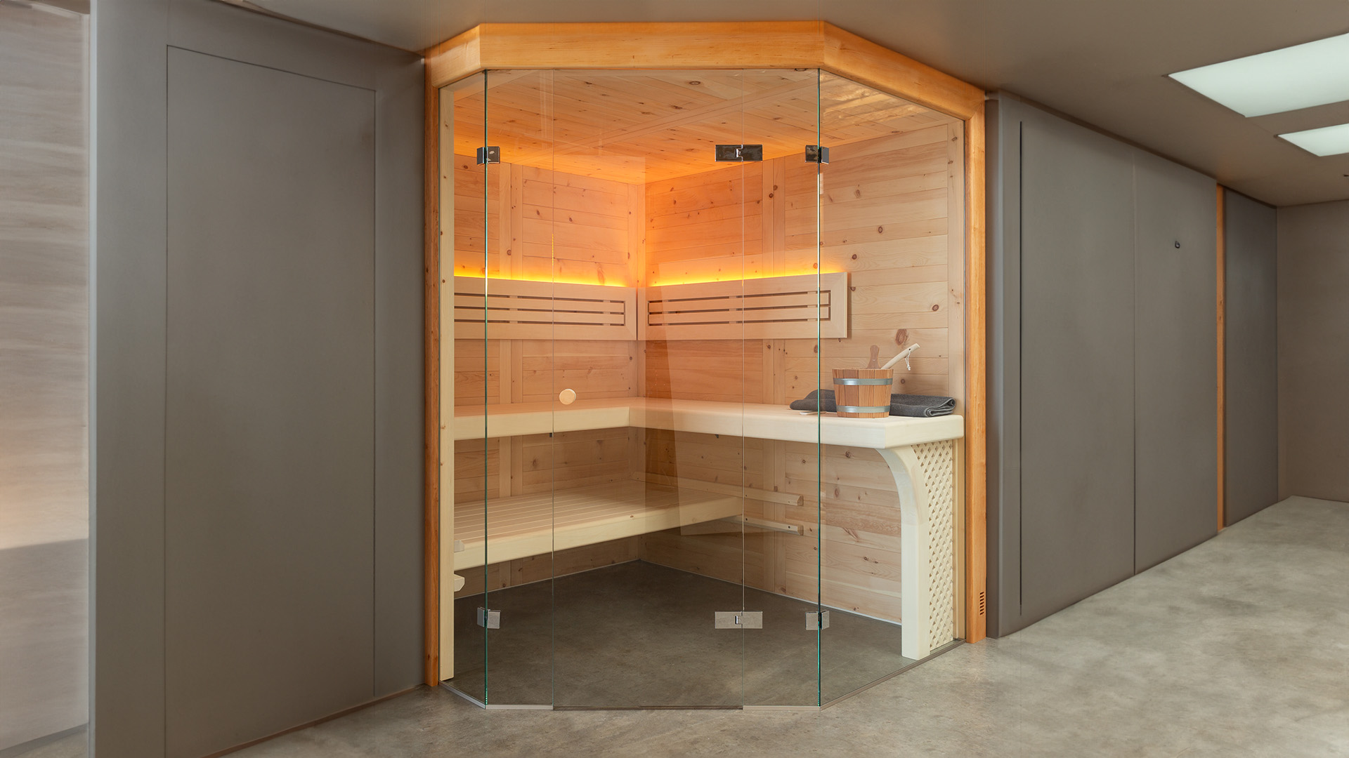 Sauna nach Maß in einem Keller in München. Sauna aus Zirbenholz und mit Glasfront hergestellt von Bauereiß Ambiente-Manufaktur Schreinerei Bad Windsheim