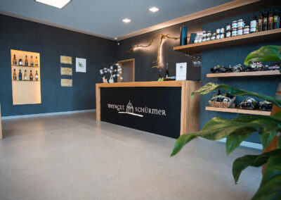 Vinothek vom Weingut Schürmer - Einrichtung aus Eiche in modern mit großzügiger Theke und Nero Assoluto Natursteinarbeitsplatte von Strasser